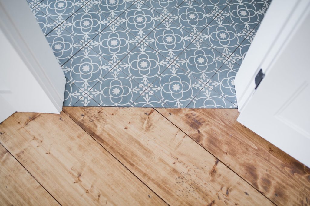 Vieux parquet à la jonction d’un carrelage en carreaux de ciment